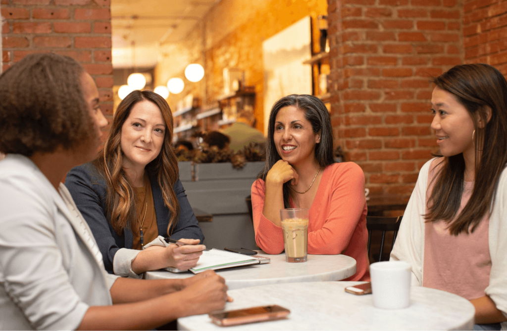 Group of people talking around a table with coffee